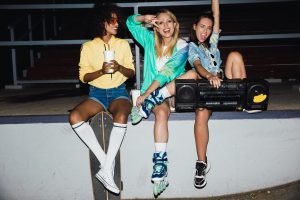 Grupo de jovens usando roupas retrô inspiradas nos anos 80 e 90 com estilo moderno.
