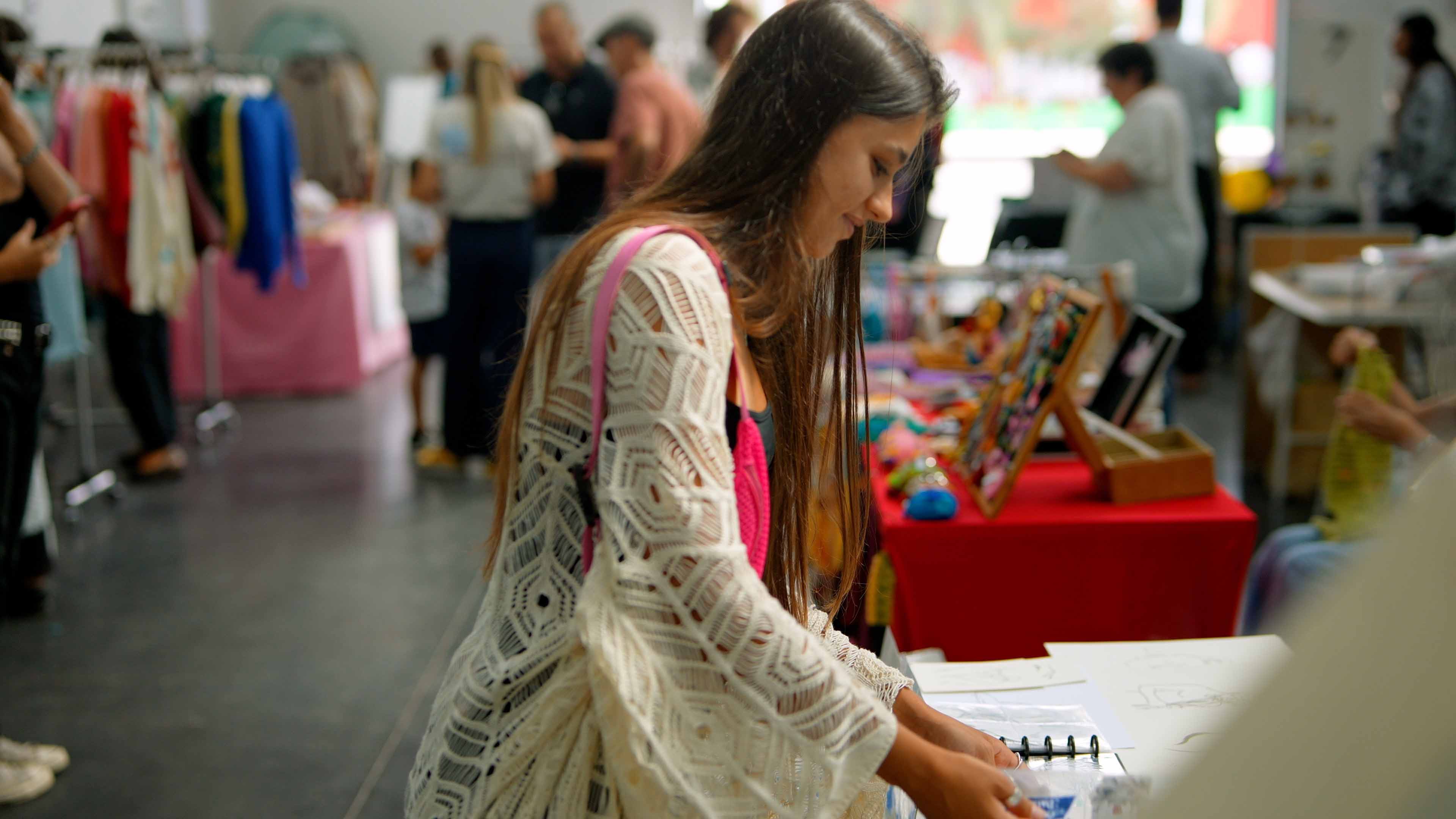 Profissional de moda analisando referências e materiais em evento criativo