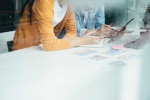 Equipe de moda analisando estampas e referências em painel criativo.